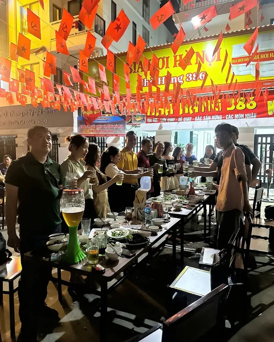 Nhóm khách nâng ly bia hơi dưới biển Nhà hàng 386